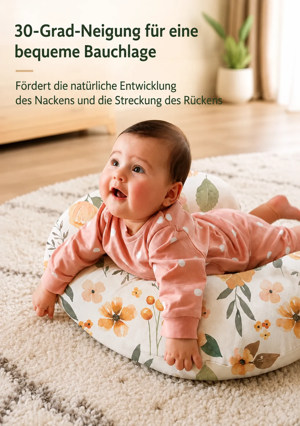 Ein Baby in Bauchlage mit den Armen auf dem geblümten Stillkissen, auf einem Teppich